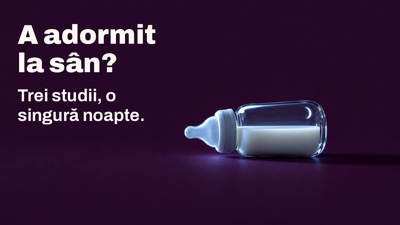 A adormit la sân? Trei studii, o singură noapte. Un mic biberon de sticlă cu lapte stă culcat pe o parte pe un fundal de prună închisă, luminat lateral de lumina rece a unui ecran nevăzut, cu o seceră subțire de lună reflectată în sticlă.