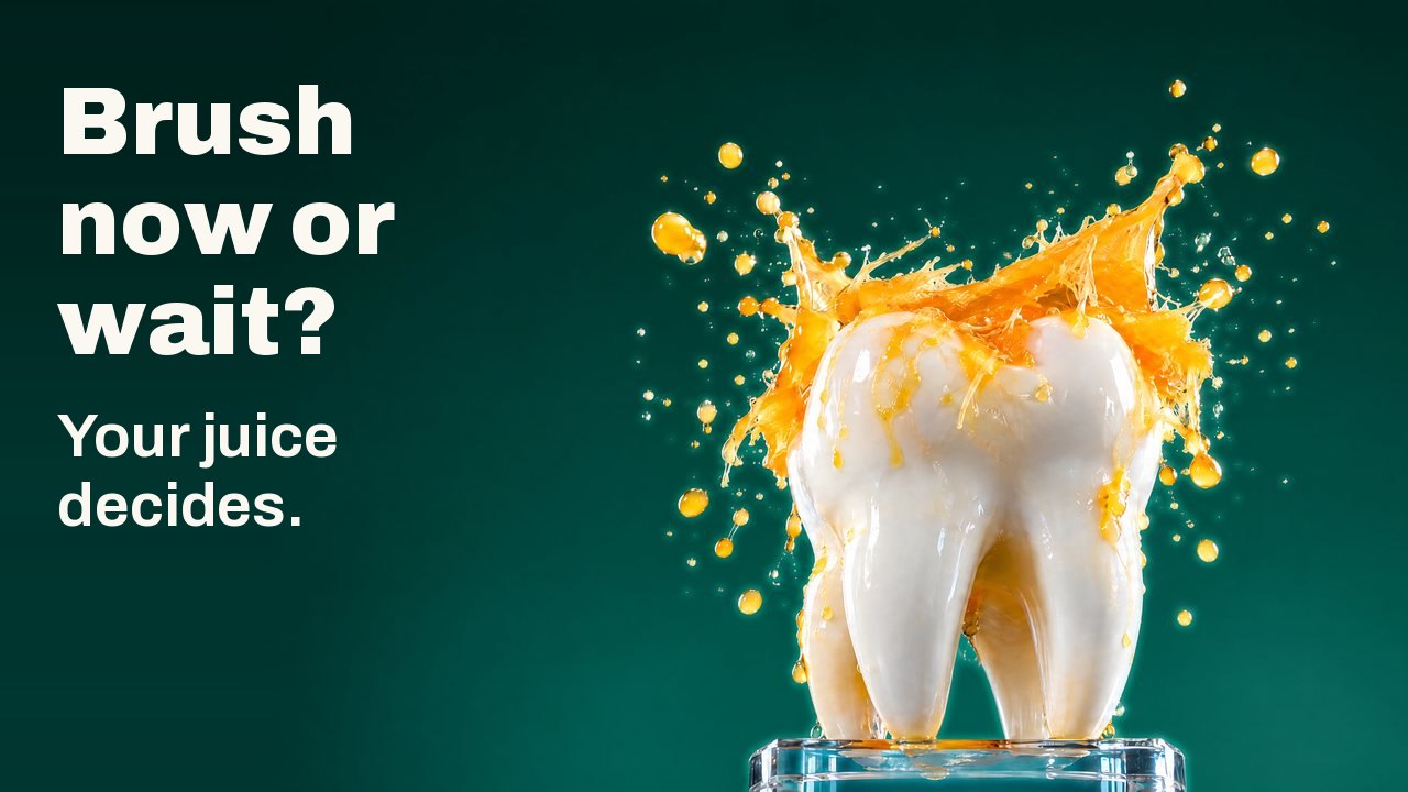 Brush now or wait? Your juice decides. A white tooth sculpture on a glass stand under a splash of orange juice frozen in mid air, against a deep green studio background.