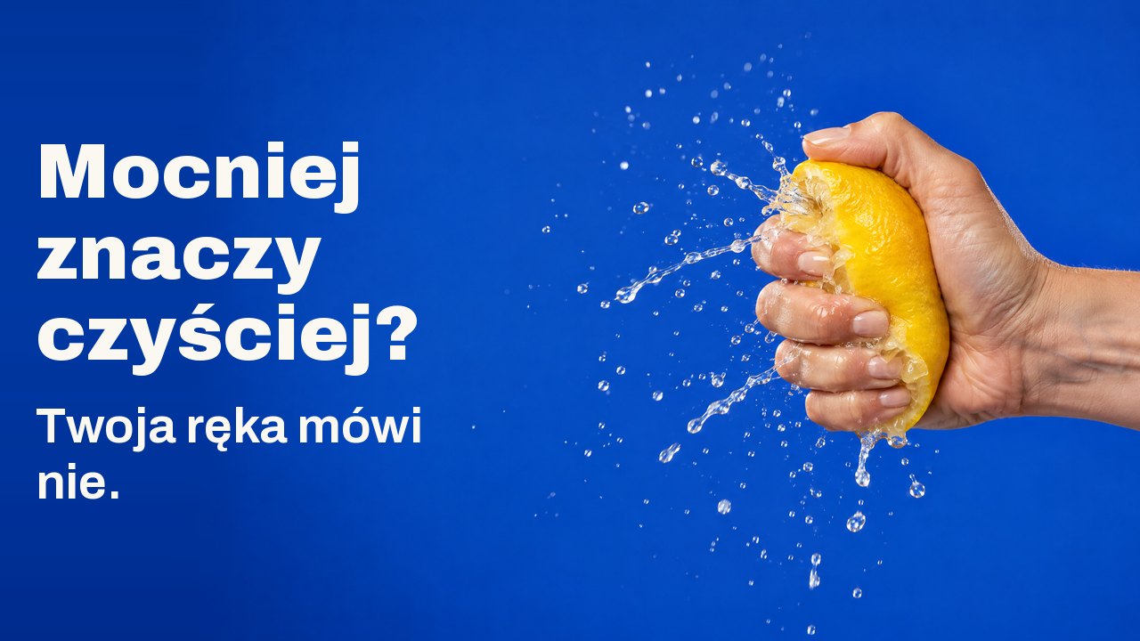 Mocniej znaczy czyściej? Twoja ręka mówi nie. Dłoń ściska cytrynę tak mocno, że sok tryska zastygłą mgiełką, na kobaltowym tle.