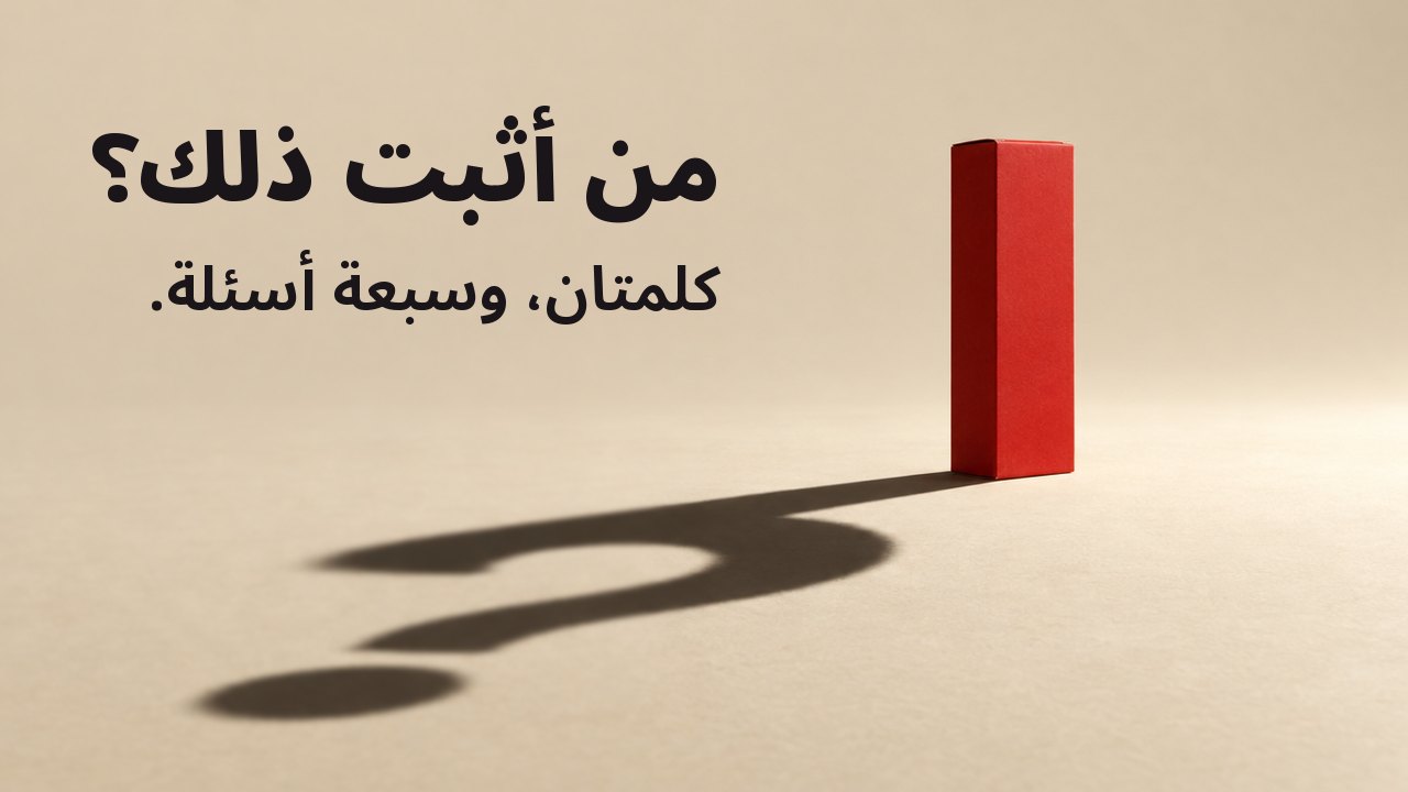 من أثبت ذلك؟ كلمتان، وسبعة أسئلة. علبة حمراء غير لامعة بلا أي كتابة تقف على أرضية بلون الكريم الدافئ تحت ضوء كشّاف واحد قوي ومنخفض؛ وظلها الطويل الحاد على الأرض يرسم علامة استفهام.