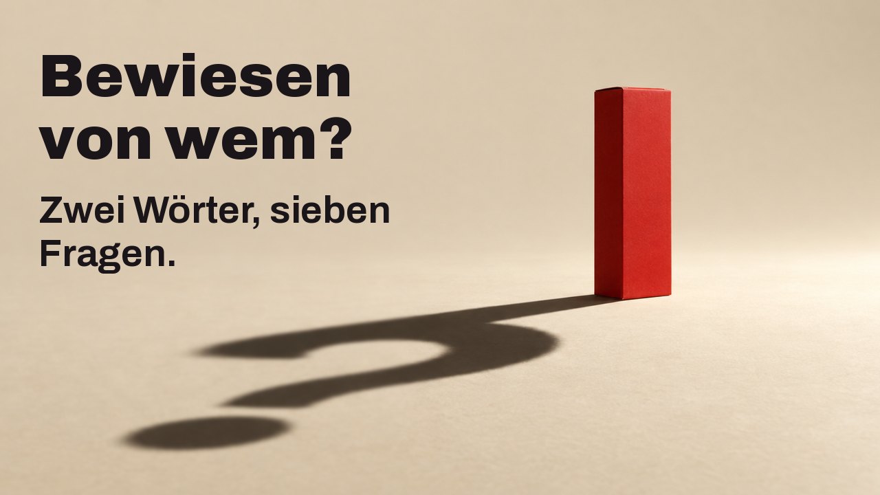 Bewiesen von wem? Zwei Wörter, sieben Fragen. Eine schlichte, matte rote Schachtel ohne Beschriftung steht auf einem warmen cremefarbenen Boden unter einem einzigen harten, tiefen Spotlicht; ihr langer scharfer Schatten auf dem Boden formt ein Fragezeichen.