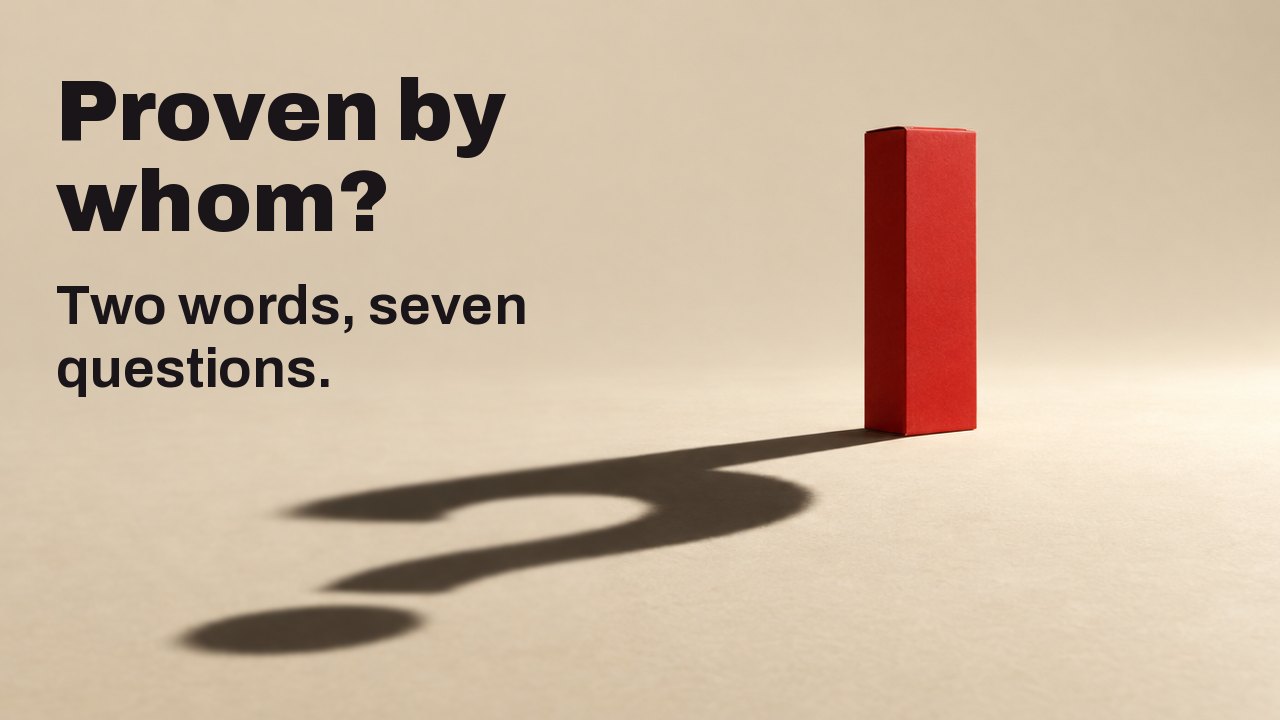Proven by whom? Two words, seven questions. A plain matte red box with no lettering stands on a warm cream floor under one hard, low spotlight; its long sharp shadow on the floor forms a question mark.
