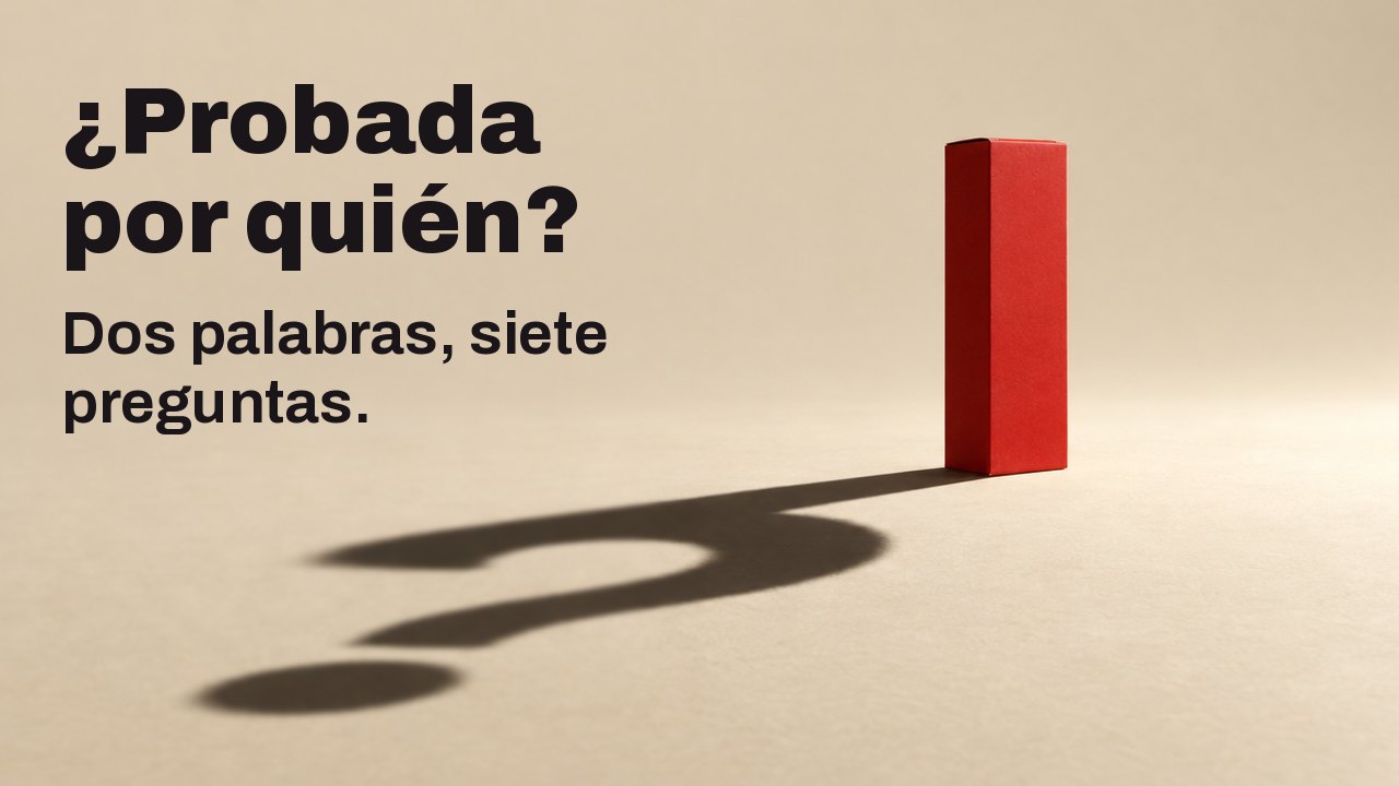 ¿Probada por quién? Dos palabras, siete preguntas. Una sencilla caja roja mate, sin ninguna letra, se alza sobre un suelo cálido color crema bajo un único foco duro y bajo; su sombra larga y nítida en el suelo forma un signo de interrogación.