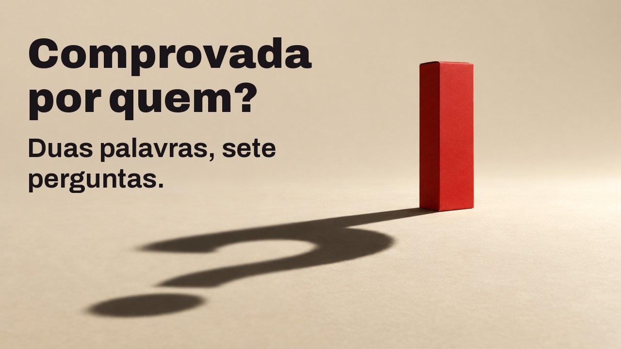 Comprovada por quem? Duas palavras, sete perguntas. Uma caixa vermelha fosca e lisa, sem nenhuma letra, está sobre um piso creme e quente sob um único holofote forte e baixo; sua sombra longa e nítida no chão forma um ponto de interrogação.