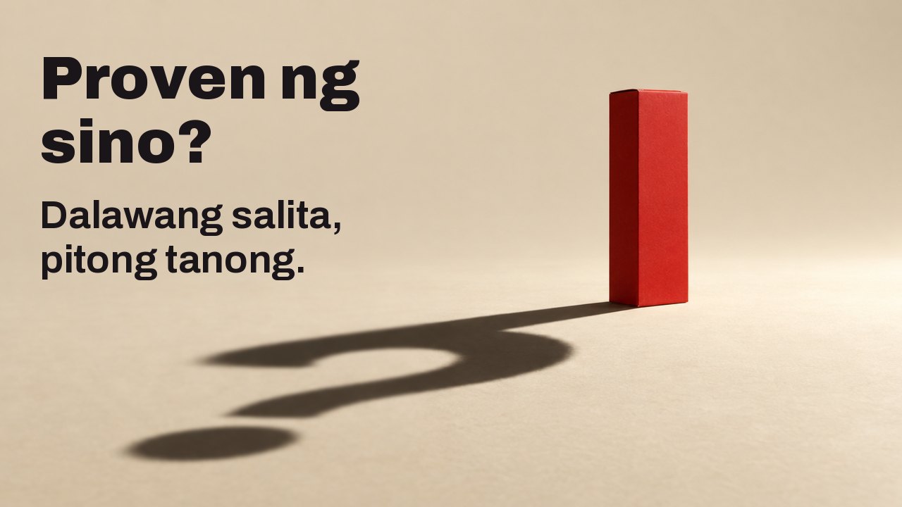 Proven ng sino? Dalawang salita, pitong tanong. Isang payak na matte na pulang kahon na walang anumang letra ang nakatayo sa mainit na kulay cream na sahig sa ilalim ng iisang matigas at mababang spotlight; ang mahaba at matalim nitong anino sa sahig ay hugis tandang pananong.
