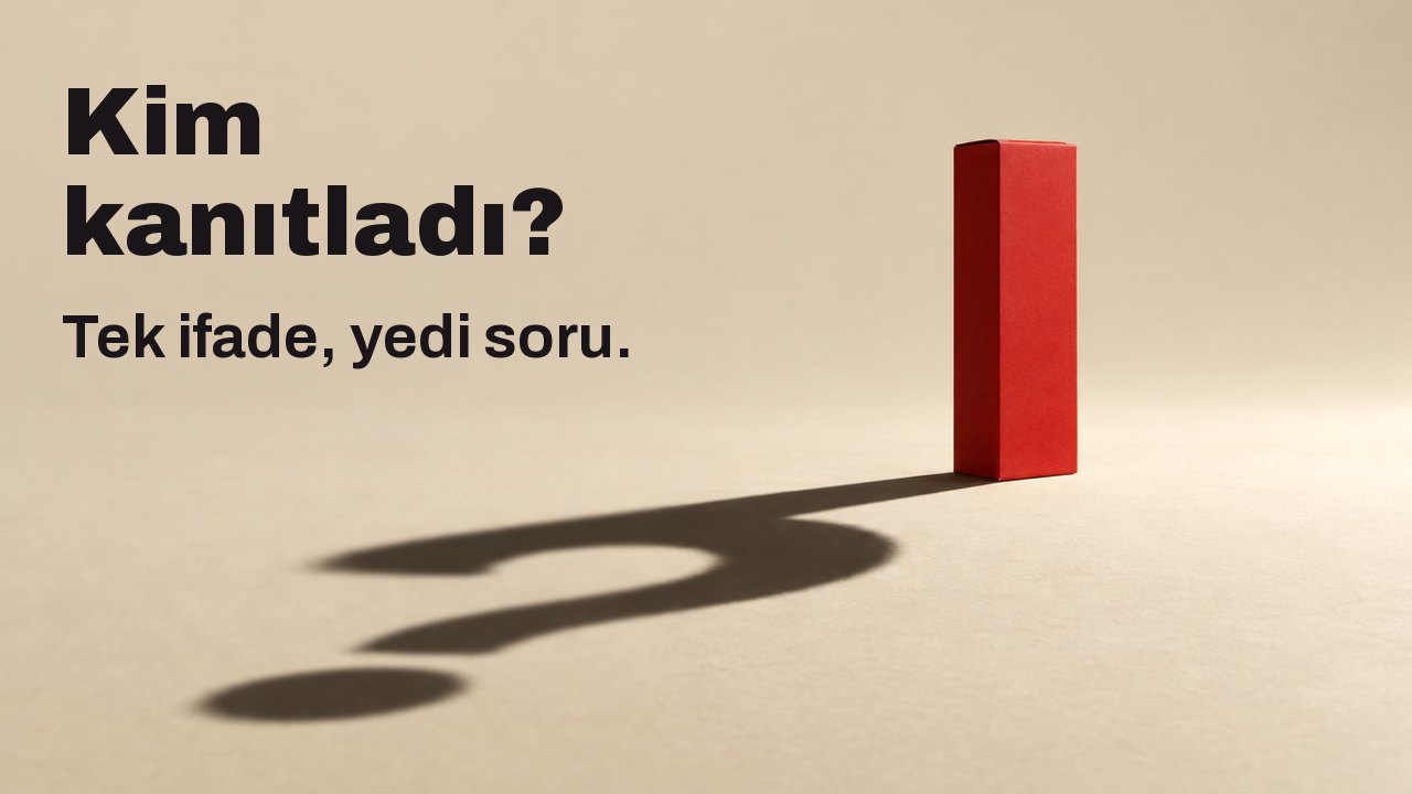 Kim kanıtladı? Tek ifade, yedi soru. Üzerinde hiç yazı olmayan sade, mat kırmızı bir kutu, sıcak krem rengi bir zeminde tek bir sert ve alçak spot ışığının altında duruyor; zemine düşen uzun, keskin gölgesi bir soru işareti çiziyor.
