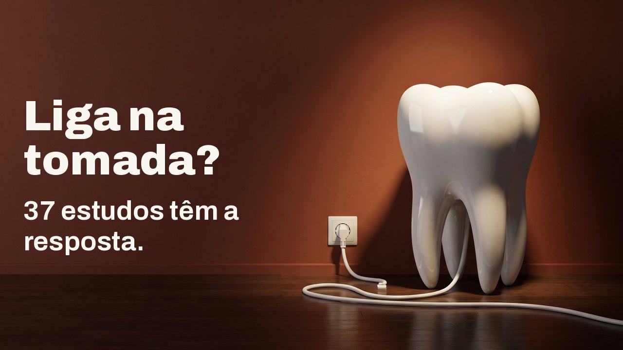 Liga na tomada? 37 estudos têm a resposta. Um modelo de dente de porcelana branca sobre um piso de madeira diante de uma parede terracota, com o cabo branco ligado na tomada da parede.