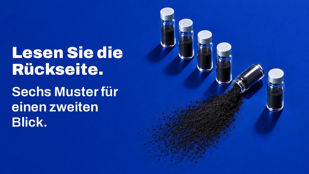 Lesen Sie die Rückseite. Sechs Muster für einen zweiten Blick. Von oben auf einer tiefen kobaltblauen Fläche: Sechs kleine Glasfläschchen stehen in einer Reihe, eines ist umgekippt und verstreut einen Fächer aus schwarzem Kohlepulver.