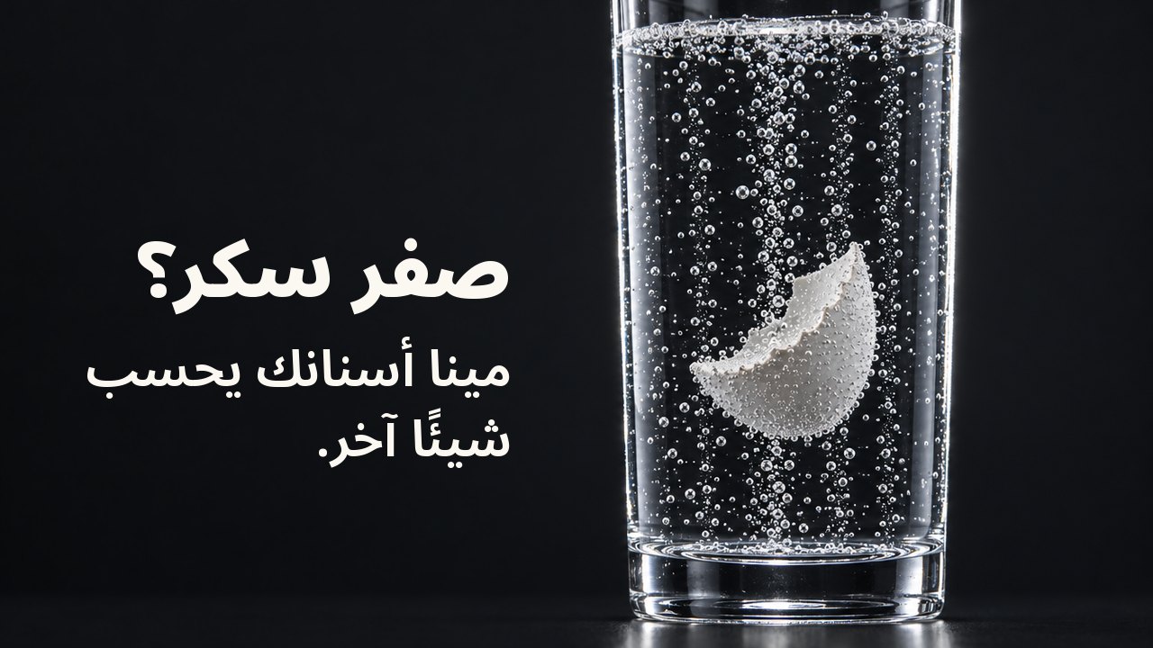 صفر سكر؟ مينا أسنانك يحسب شيئًا آخر. شظية بيضاء من قشر البيض معلقة في كأس طويلة من صودا شفافة فوّارة، وخيوط الفقاعات تصعد بجانبها على خلفية زرقاء كوبالتية عميقة.
