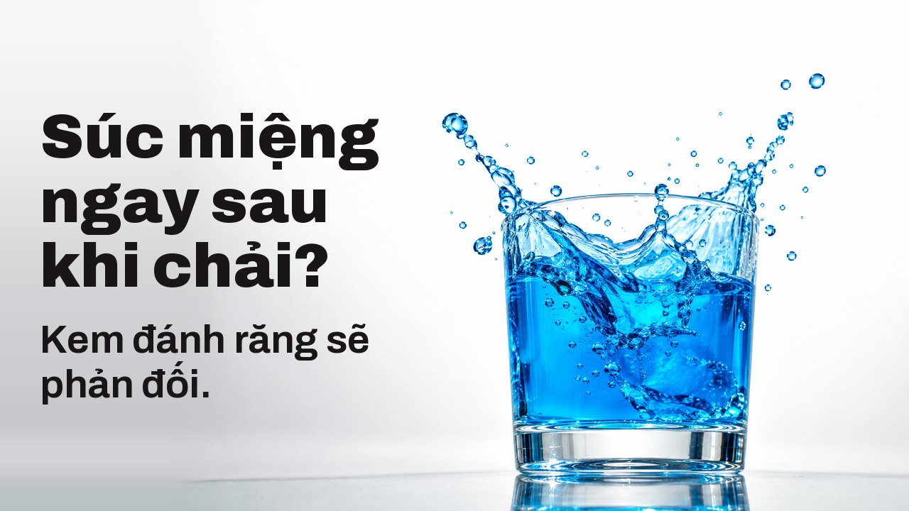 Súc miệng ngay sau khi chải? Kem đánh răng sẽ phản đối. Nước súc miệng xanh dương rực bắn lên từ chiếc ly trong suốt, đông cứng giữa không trung, trên nền studio trắng.