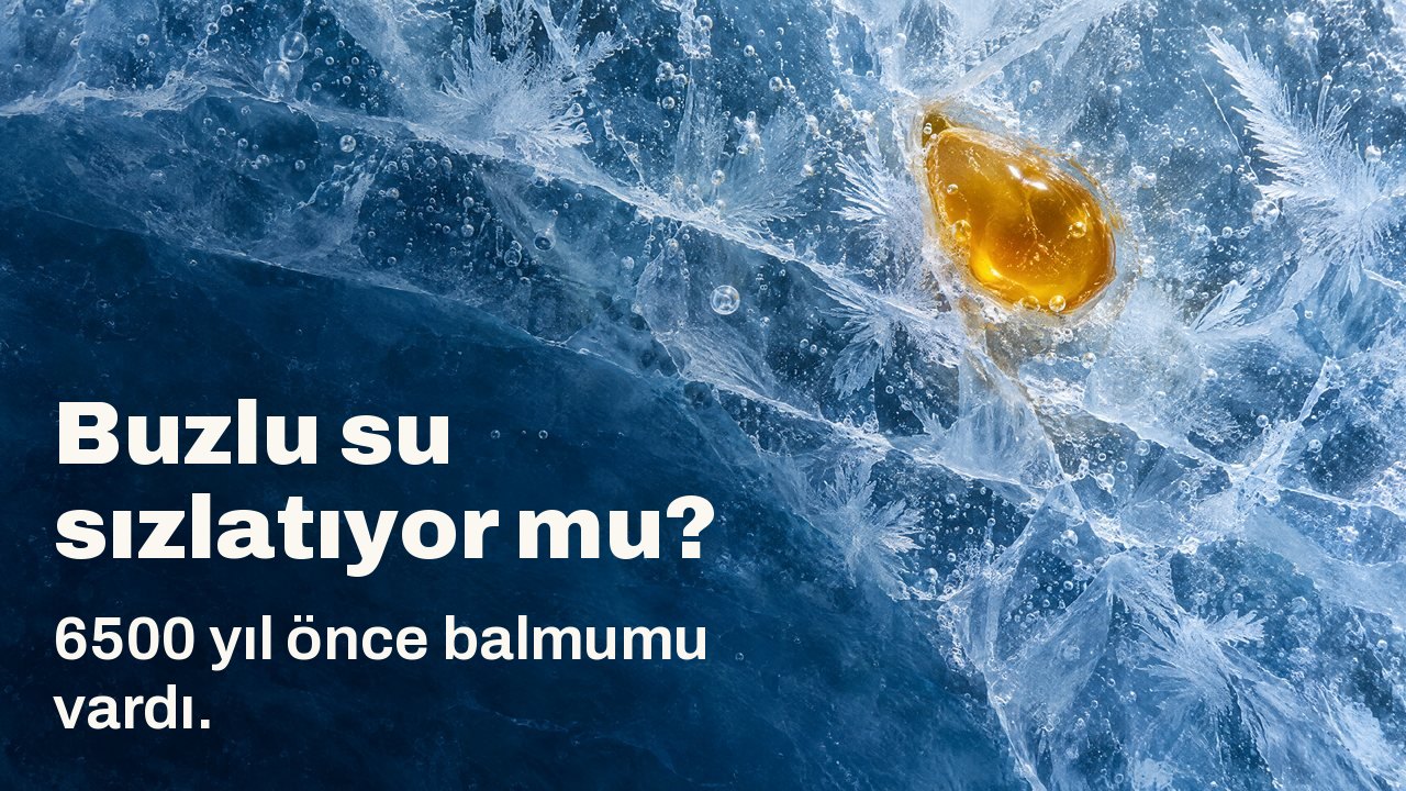Buzlu su sızlatıyor mu? 6500 yıl önce balmumu vardı. Yukarıdan: çatlak mavi buzun içinde donmuş altın renkli bir damla balmumu, buz çiçekleri ve hava kabarcıklarıyla.