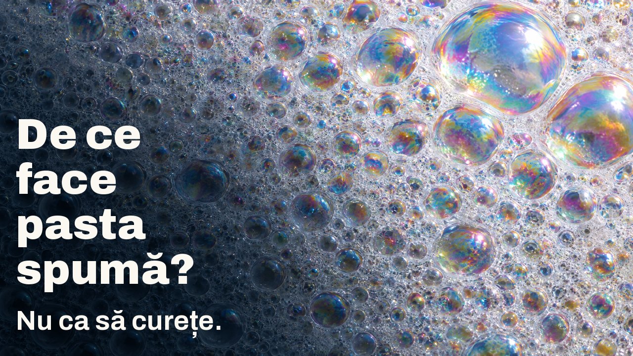 De ce face pasta spumă? Nu ca să curețe. Macro de spumă albă: nenumărate bule mici cu peliculă irizată, câteva bule mari prind lumina.