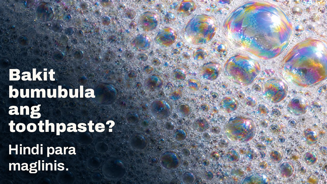 Bakit bumubula ang toothpaste? Hindi para maglinis. Macro ng puting bula: hindi mabilang na maliliit na bula na may makinang na kulay bahaghari, ilang malalaki ang sumasalo ng liwanag.
