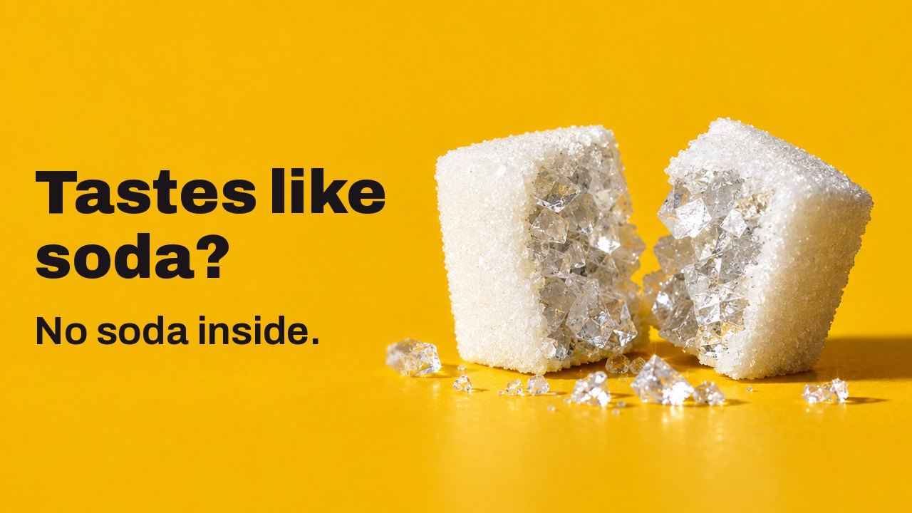 Tastes like soda? No soda inside. An extreme close up from table height on a warm saffron yellow ground: a white sugar cube split in two, and inside it not sugar but large glassy crystals of salt.