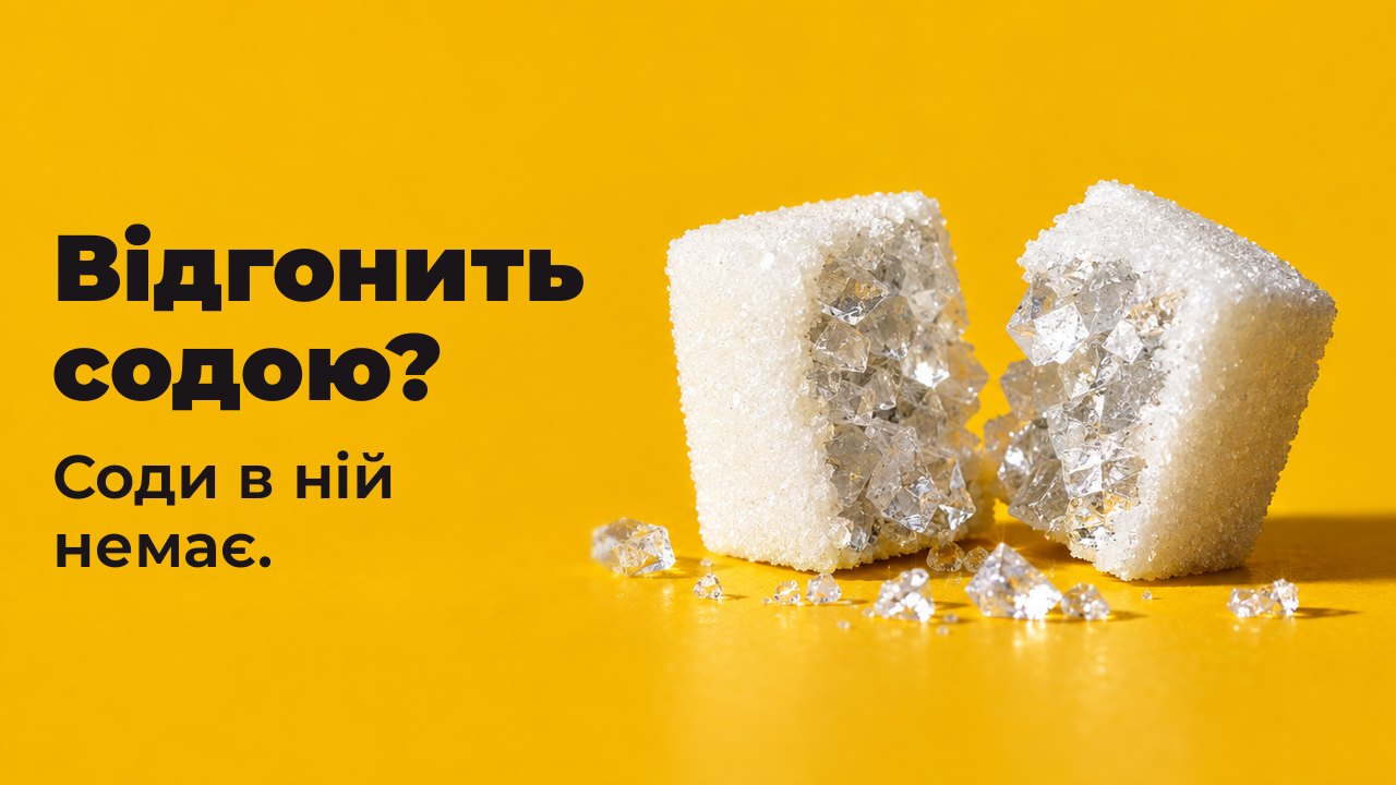 Відгонить содою? Соди в ній немає. Макро з висоти столу на теплому шафрановому тлі: шматочок рафінаду розколото навпіл, а всередині не цукор, а великі прозорі кристали солі.