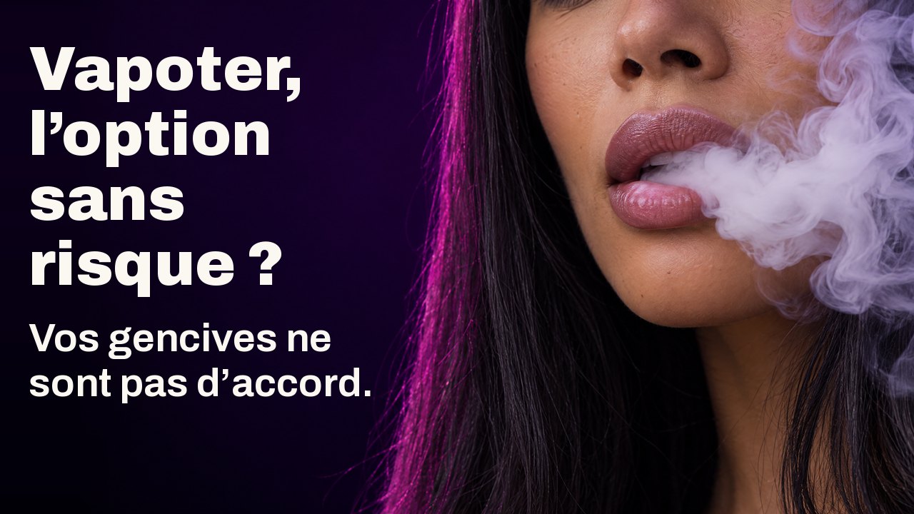Vapoter, l’option sans risque ? Vos gencives ne sont pas d’accord. Gros plan sur les lèvres d’une femme exhalant un épais nuage de vapeur blanche tourbillonnant, sur fond violet sombre.